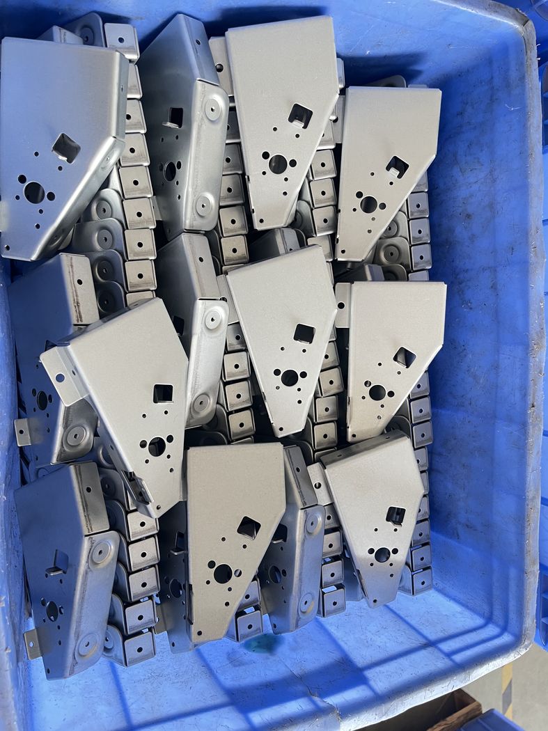 Formed hinge parts in a crate.